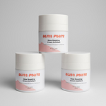 Three jars of Bliss Forte skincare products on a pink background